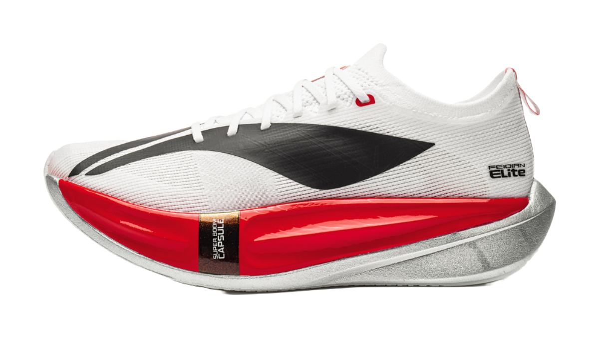 White low running shoe with black panel, red sole, and lace-up front
