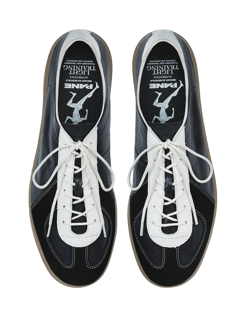Front view of black low-top sneakers with white laces and white stitching