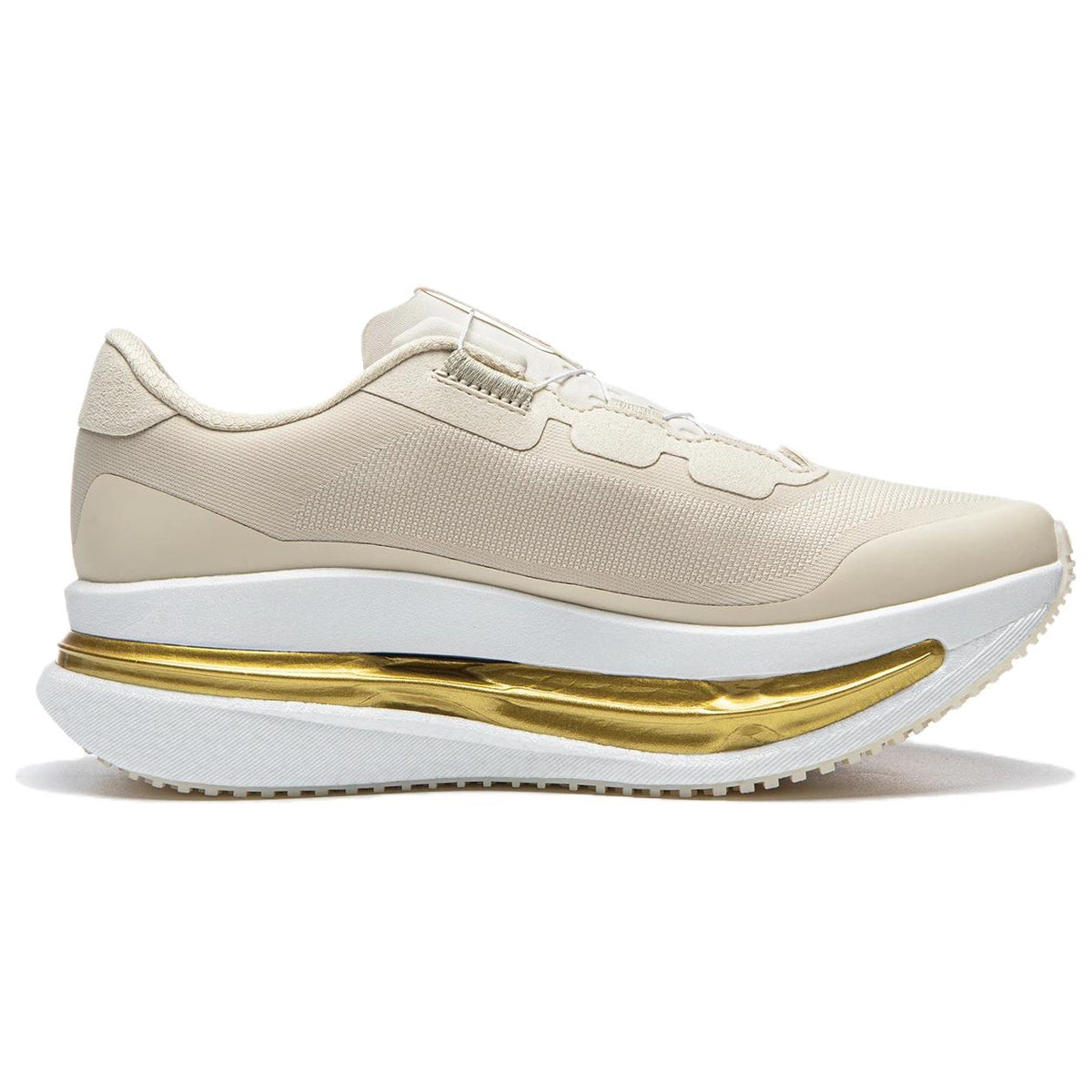 Women’s running shoes in light beige with textured upper and gold midsole stripe.