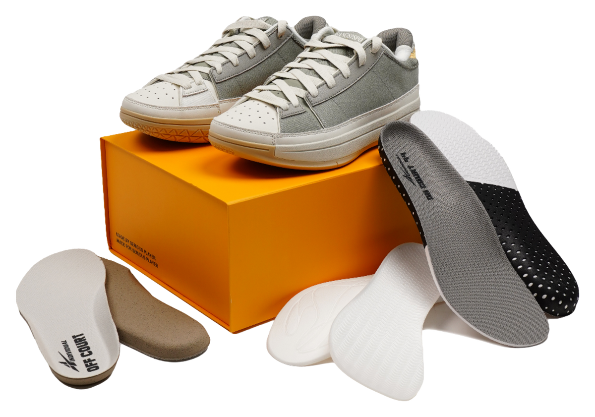 Unisex basketball shoes on an orange box with spare insoles and socks