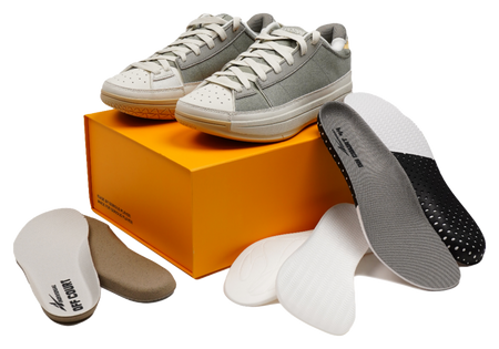 Unisex basketball shoes on an orange box with spare insoles and socks