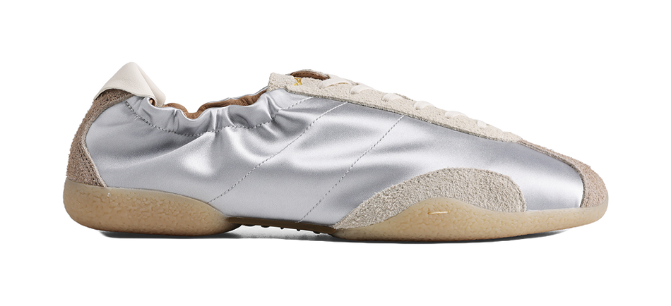 Low-top silver sneaker profile with beige textured sole and off-white laces