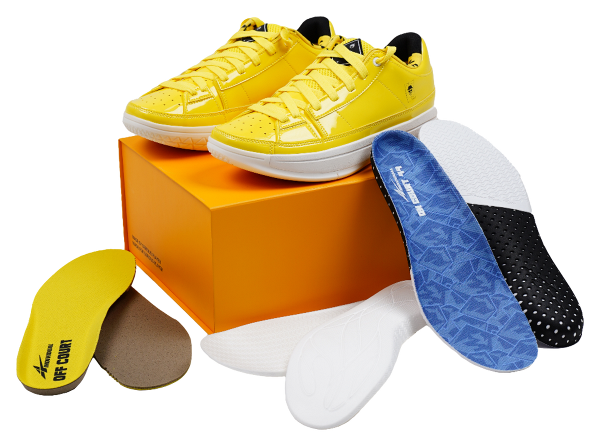 Yellow lace-up basketball shoes placed on an orange shoebox