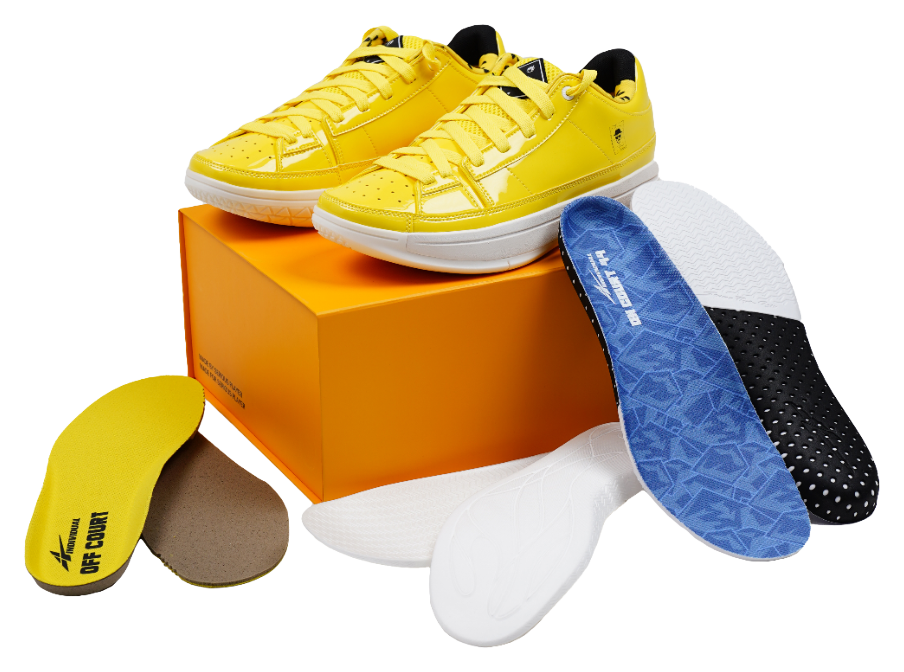 Yellow lace-up basketball shoes placed on an orange shoebox