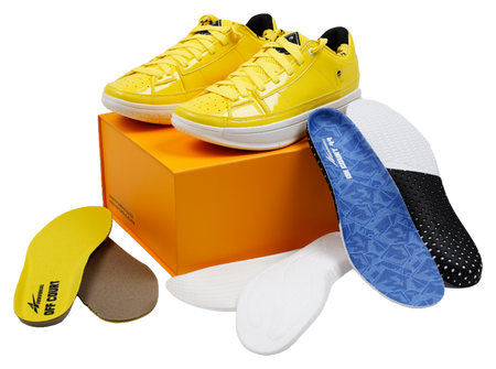 Yellow lace-up basketball shoes placed on an orange shoebox