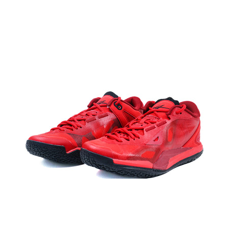Pair of red low-top basketball shoes with lace-up design and textured uppers