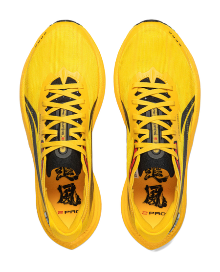 Pair of yellow low-top running shoes with black laces and patterned tongue label.