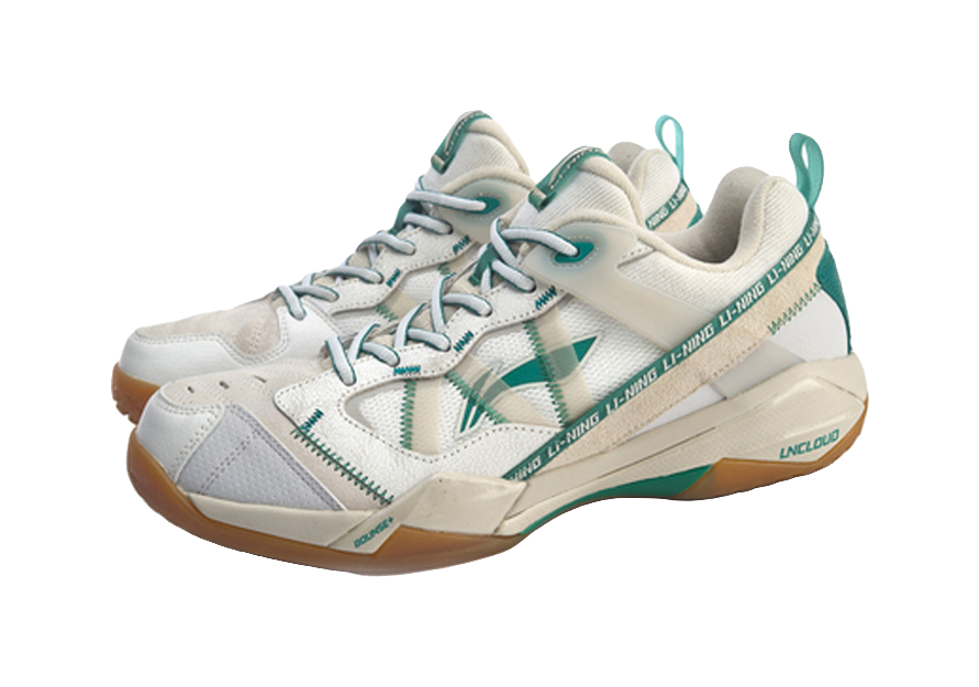 Pair of white-and-gray badminton shoes with green details, laces and side logos