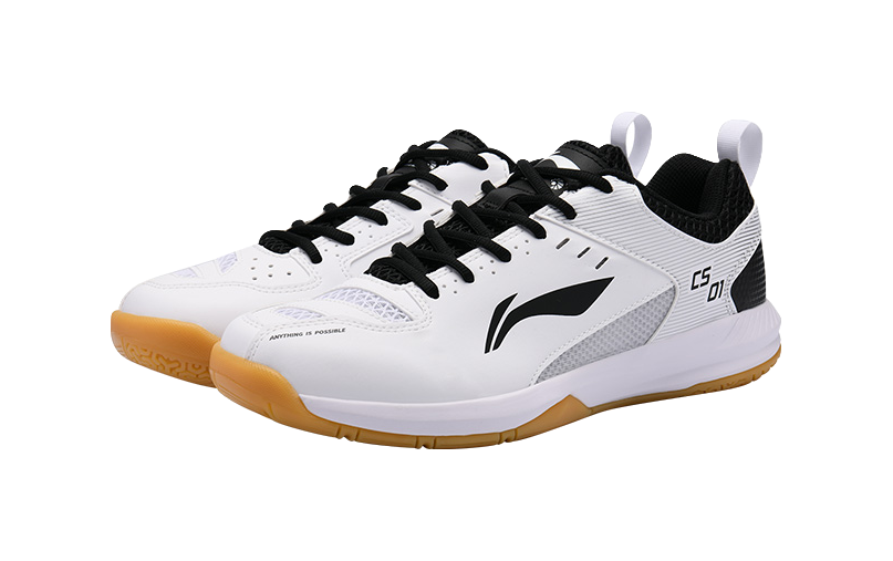 Unisex badminton shoe in white with black laces and orange gum outsole, angled front