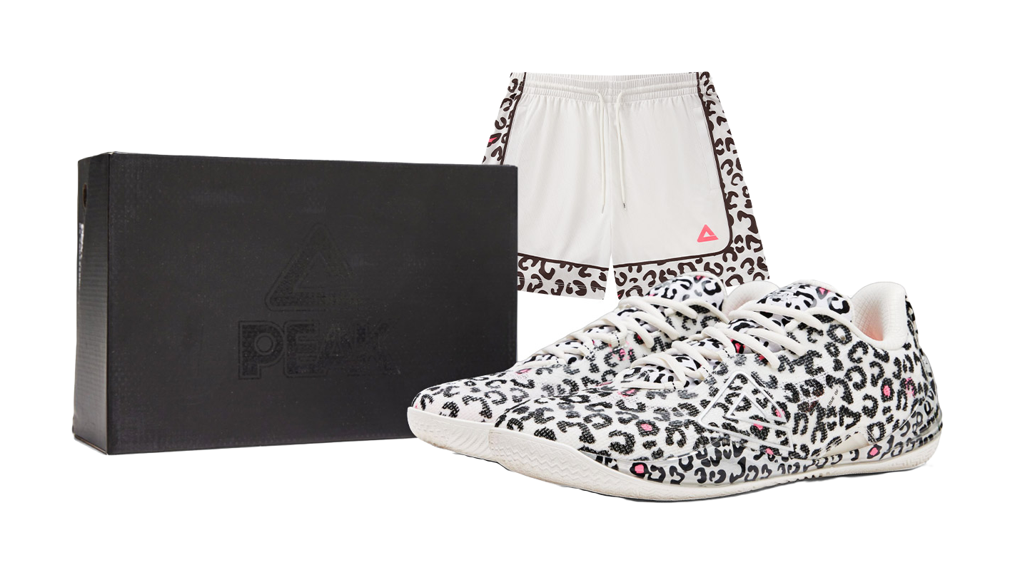 Pair of white low-top basketball shoes with black leopard print and pink accents