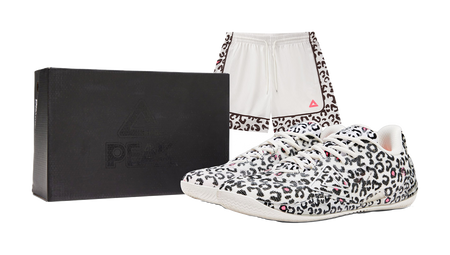 Pair of white low-top basketball shoes with black leopard print and pink accents