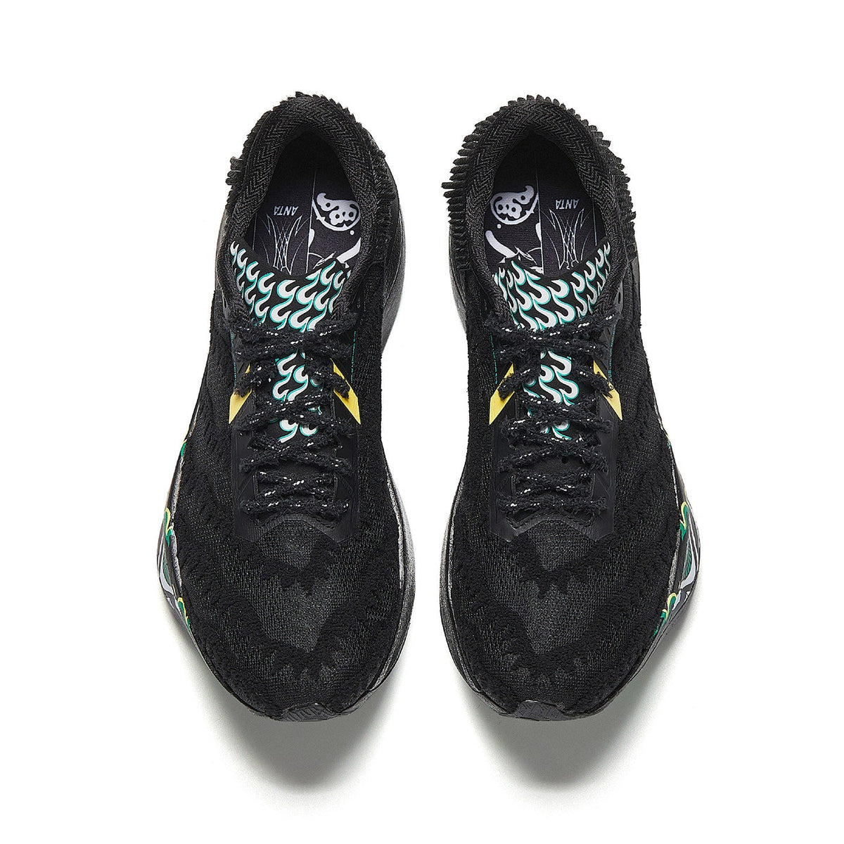 Pair of black running shoes with patterned inner lining and green flame graphics.