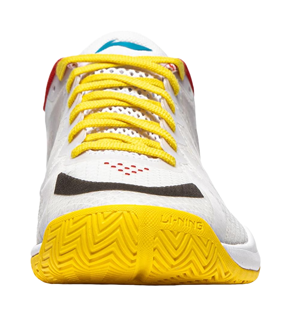 White table tennis shoe with yellow laces and yellow textured outsole tread