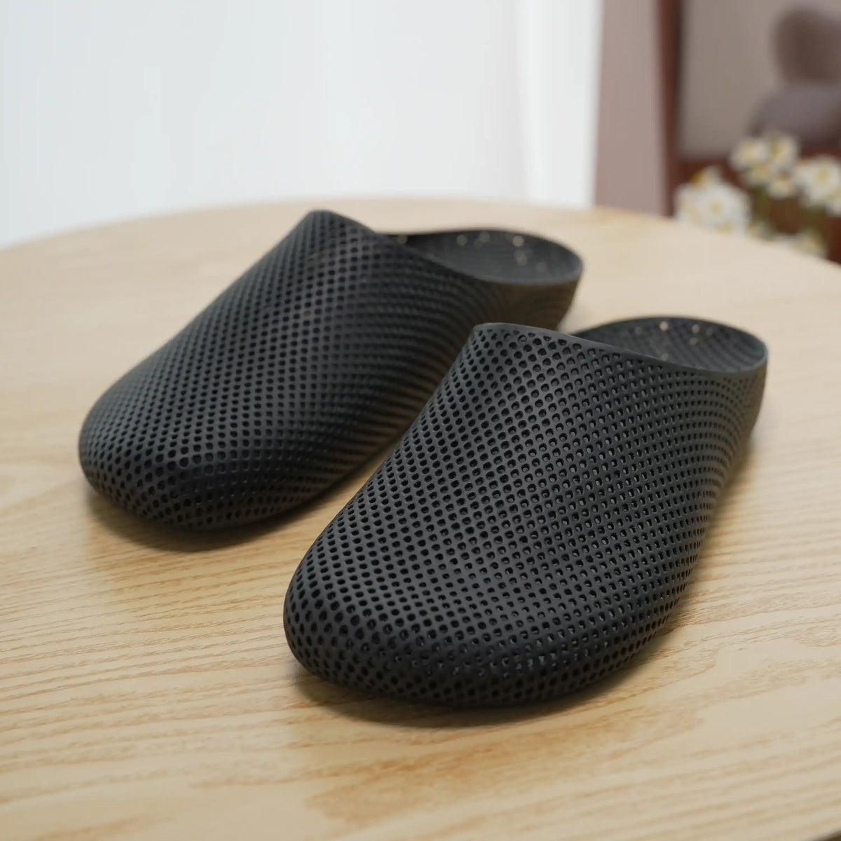 Black 3D printed slip-on slippers with perforated textured upper