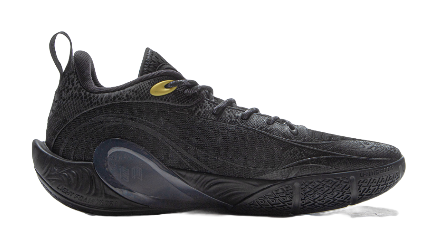 Black low-top basketball shoe with textured upper and gold logo accents