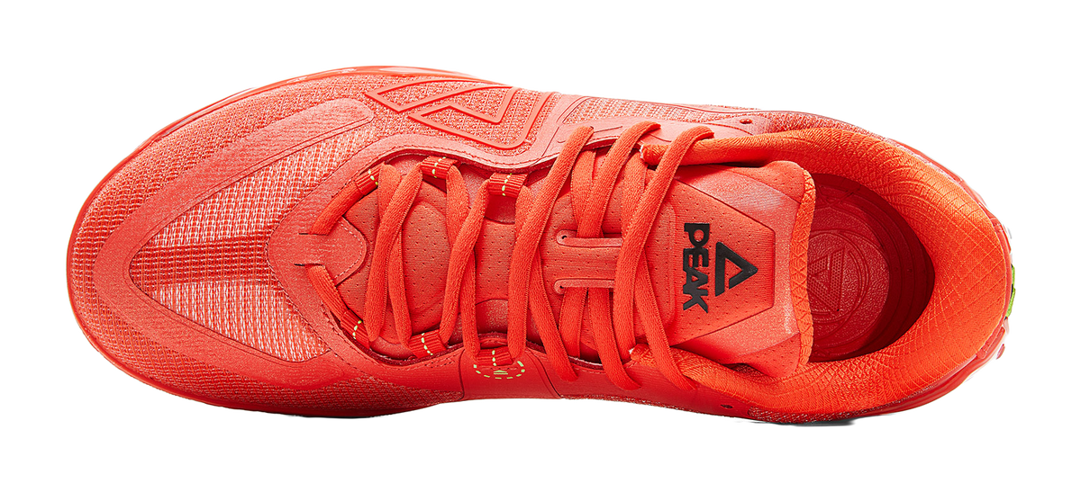 Orange-red lace-up basketball shoe, top view of tongue, laces, and patterned upper.