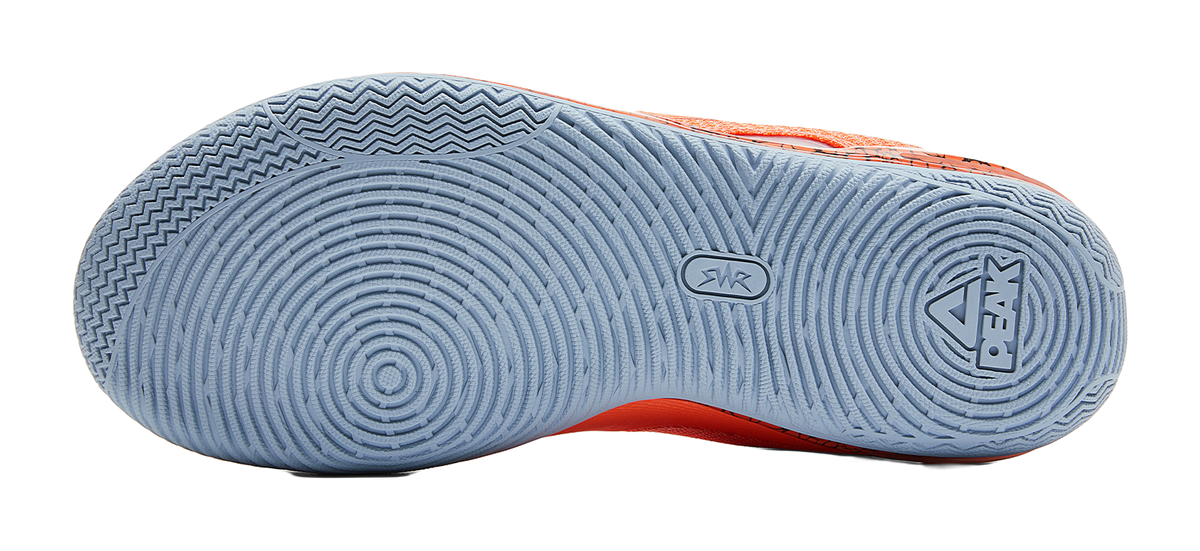 Light blue outsole of orange basketball shoe with tread and logo marks
