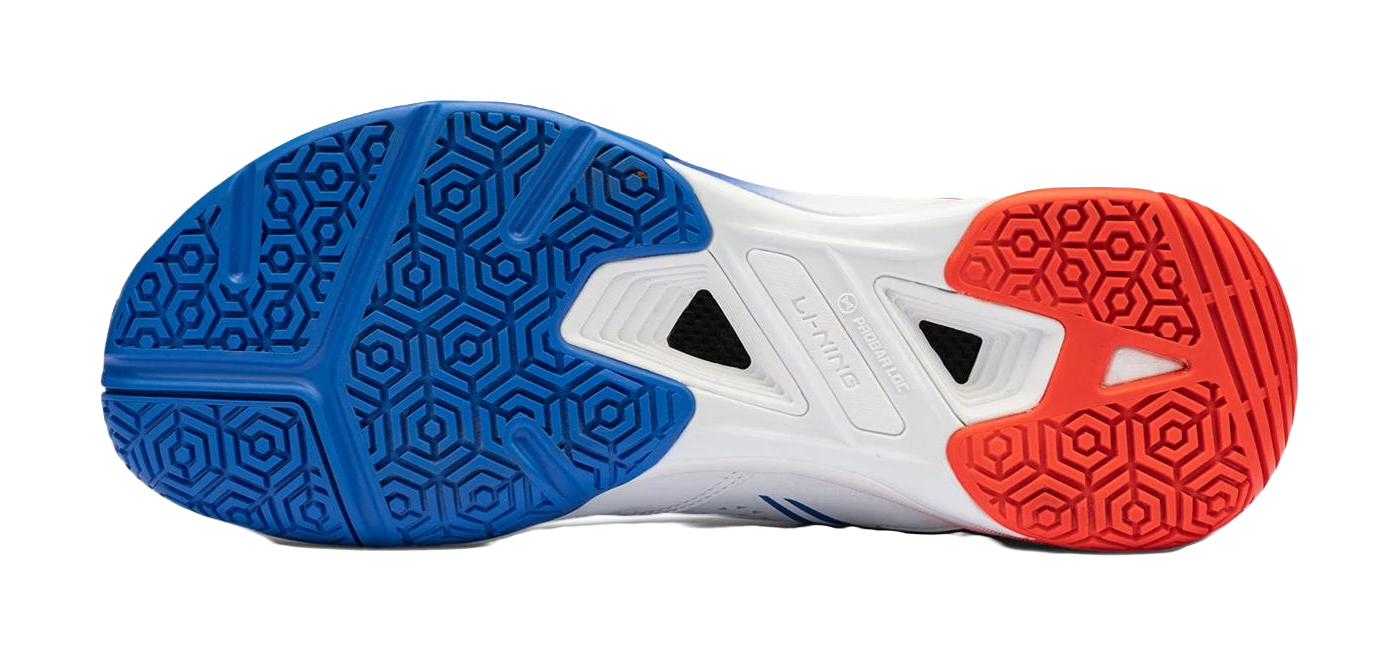 Badminton shoe outsole in blue and red with hex tread and center vent grips
