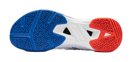 Badminton shoe outsole in blue and red with hex tread and center vent grips