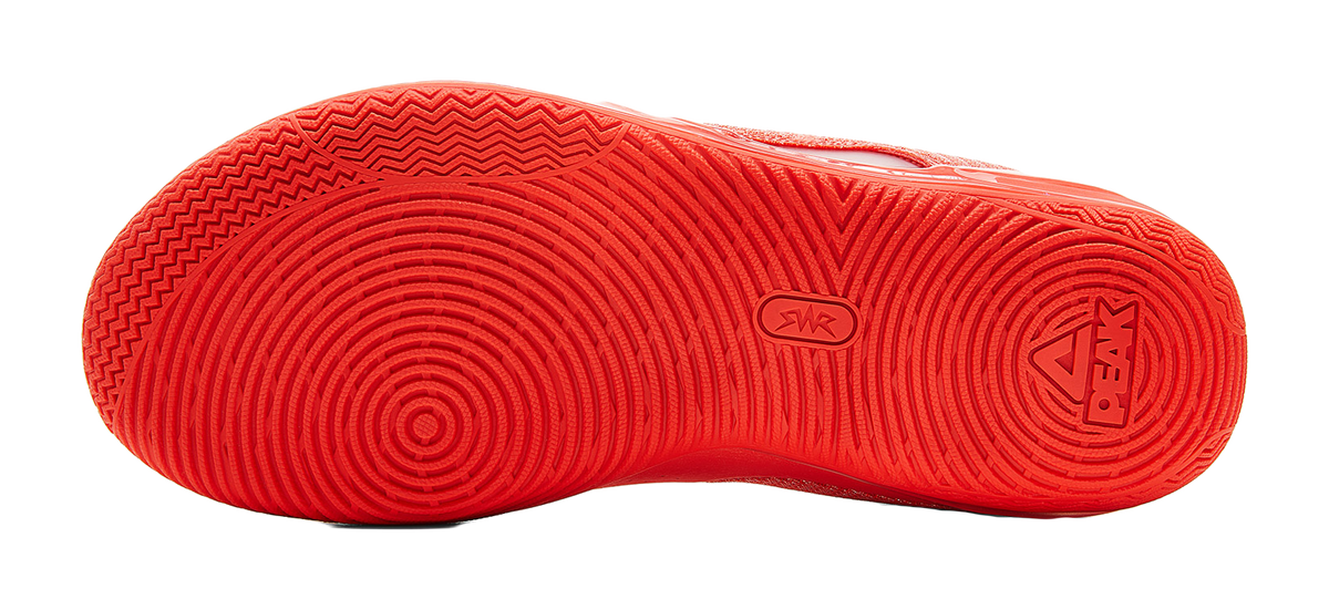 Orange-red rubber outsole with textured tread and traction pattern, bottom view.