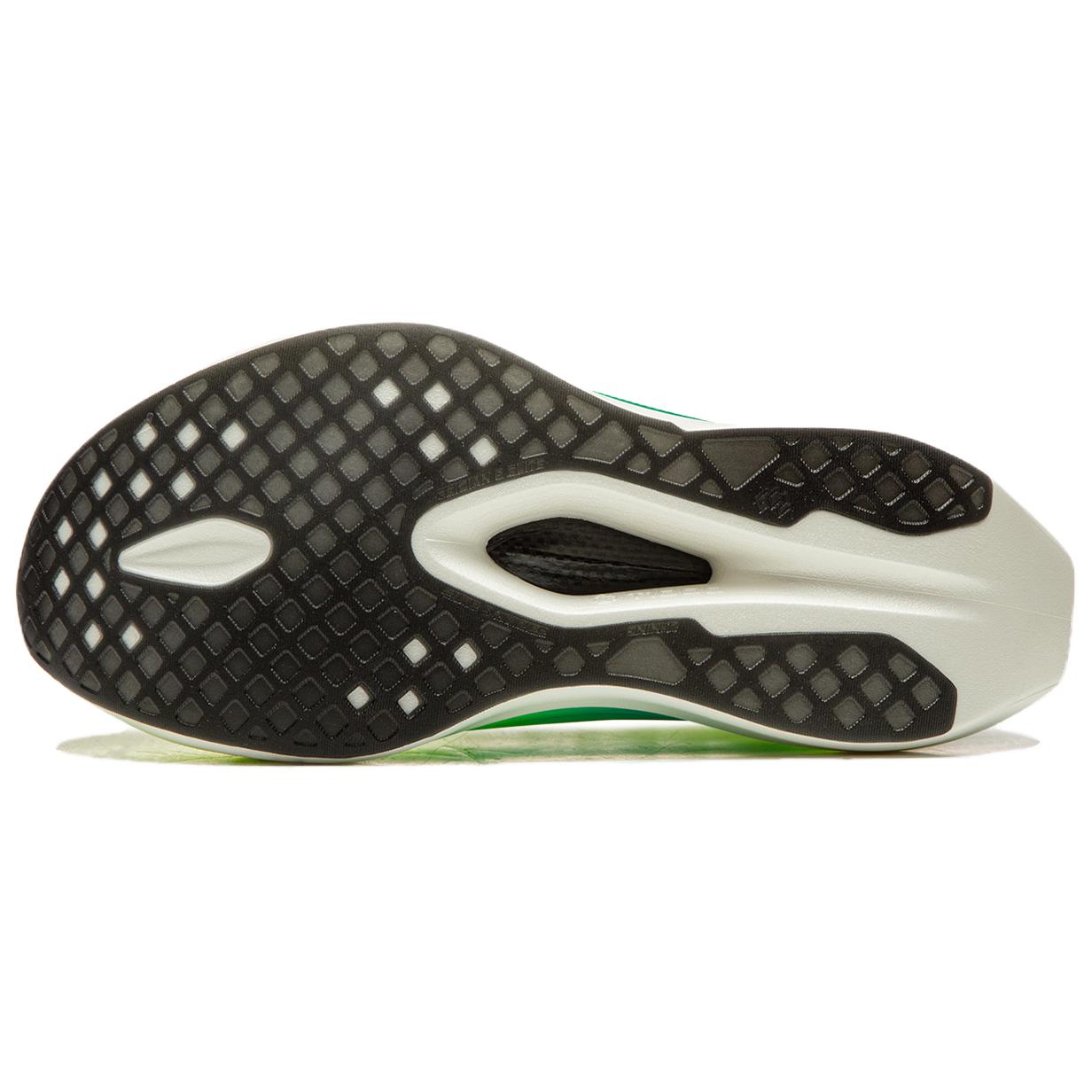 Racing shoe outsole with black traction pattern, white pods, green edge.