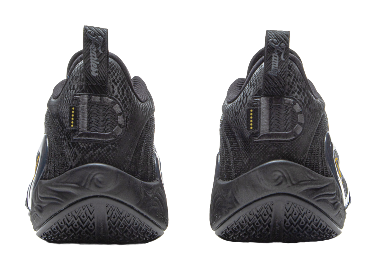 Black basketball shoes with heel tabs and treaded sole, gold vertical accents