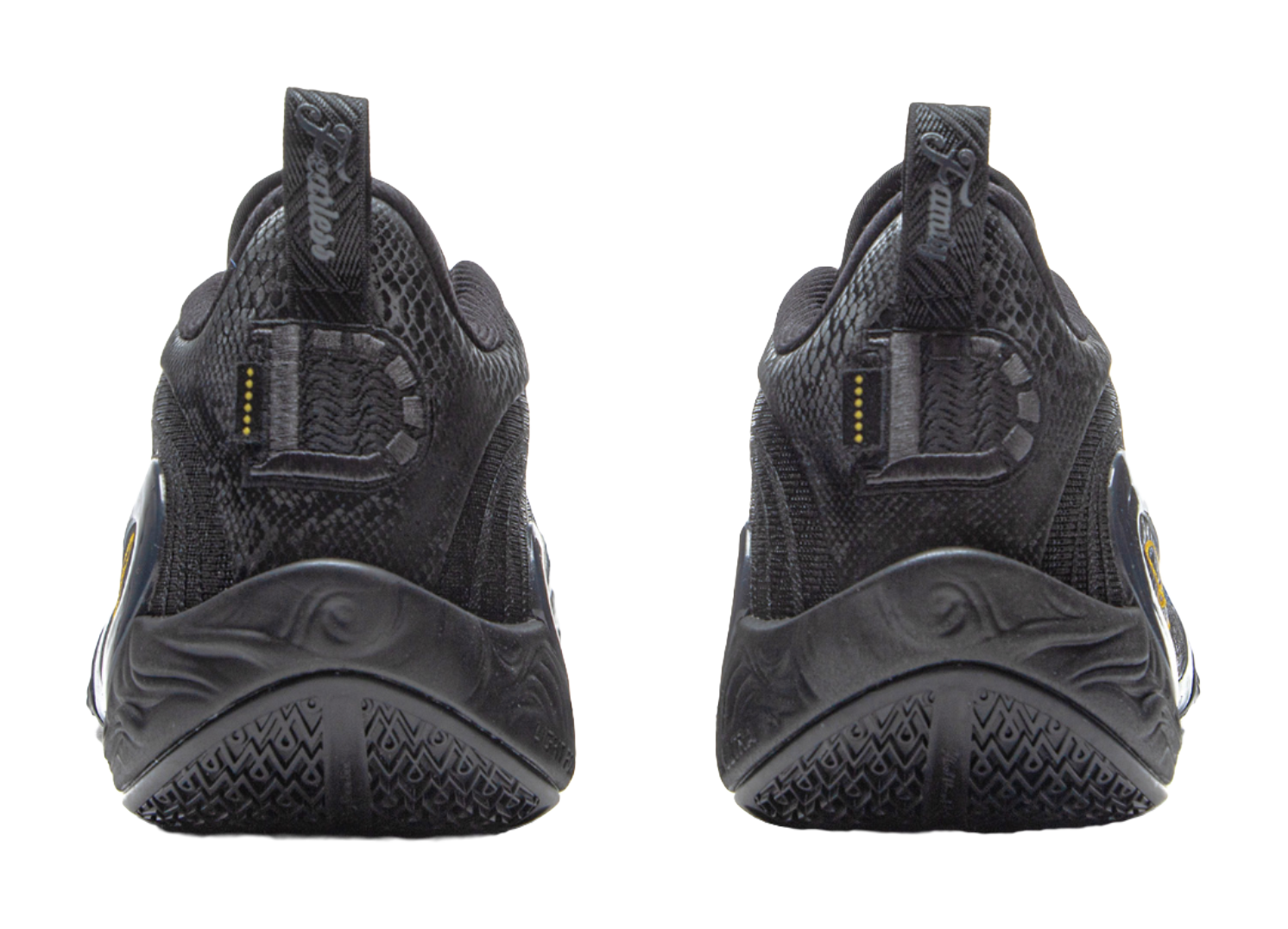 Black basketball shoes with heel tabs and treaded sole, gold vertical accents