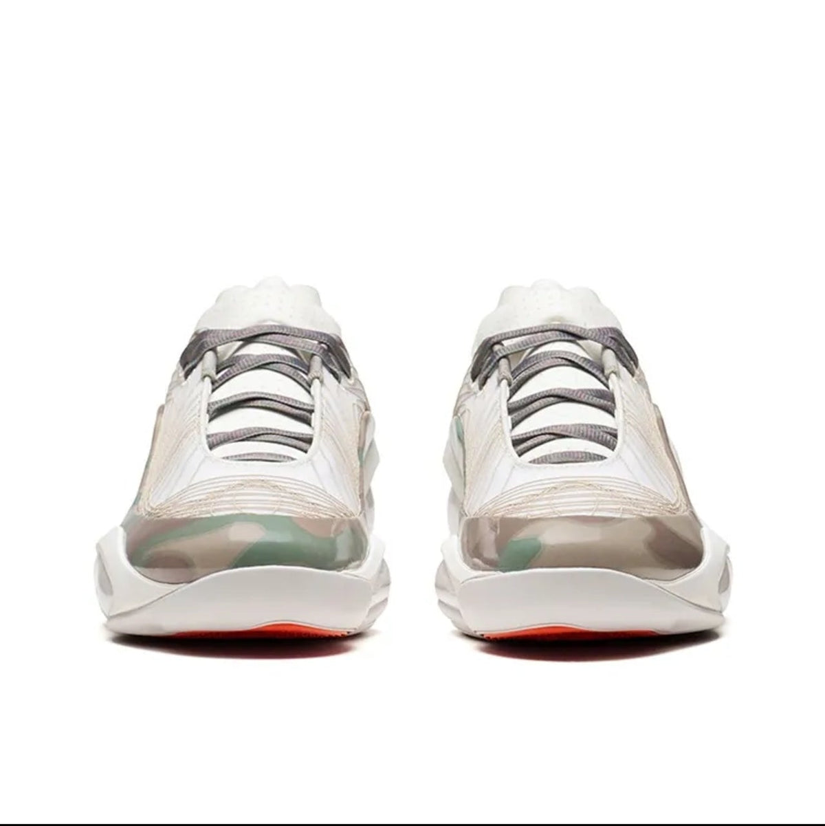 A pair of low-top sneakers shown from the back, featuring translucent white and gray overlays, gray laces, and a white sole with a small red accent on the outsole.