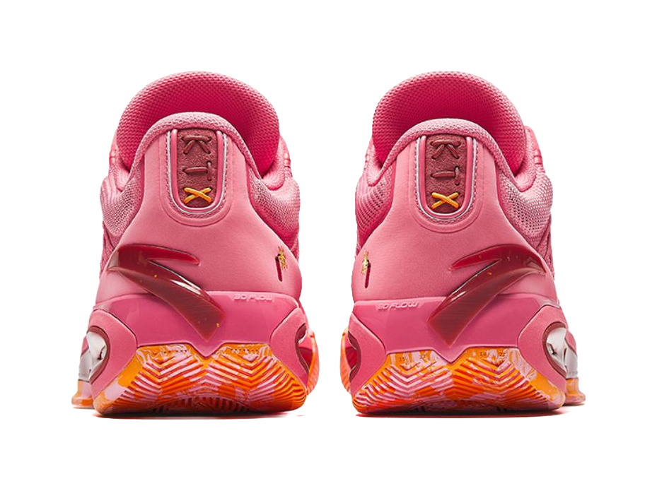 Pink low basketball shoes with rear tabs, lace loops, and orange patterned outsole