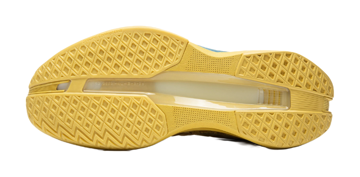 Bright gold rubber outsole with textured traction pattern on low-top basketball shoes