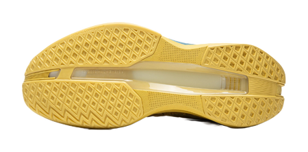 Bright gold rubber outsole with textured traction pattern on low-top basketball shoes