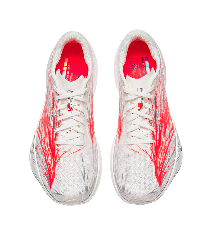 Pair of white running shoes with red patterned sides, lace-up with red interior