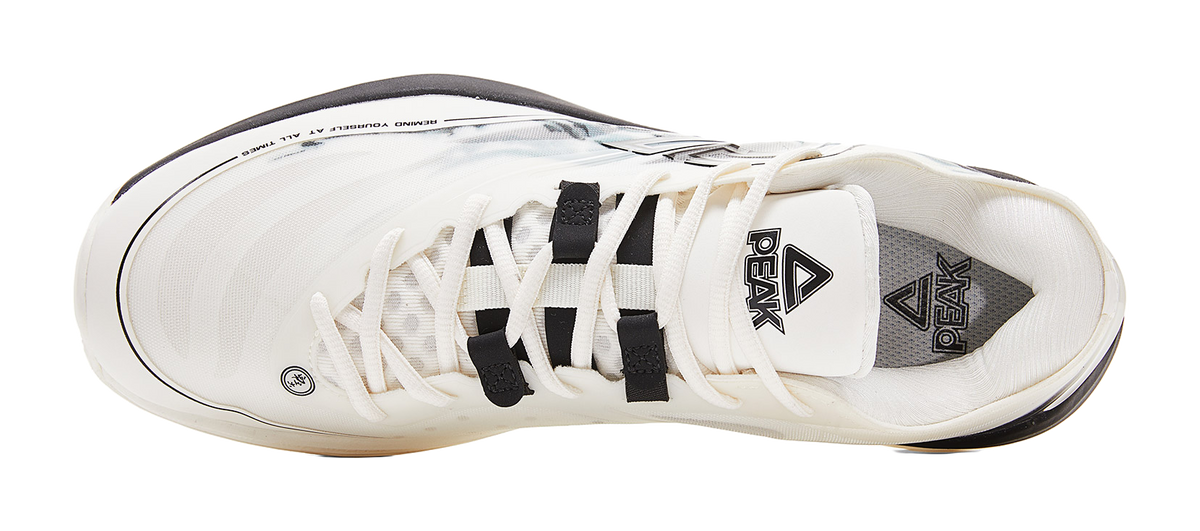 Lightweight basketball shoe, cream upper with black laces and interior logo patch