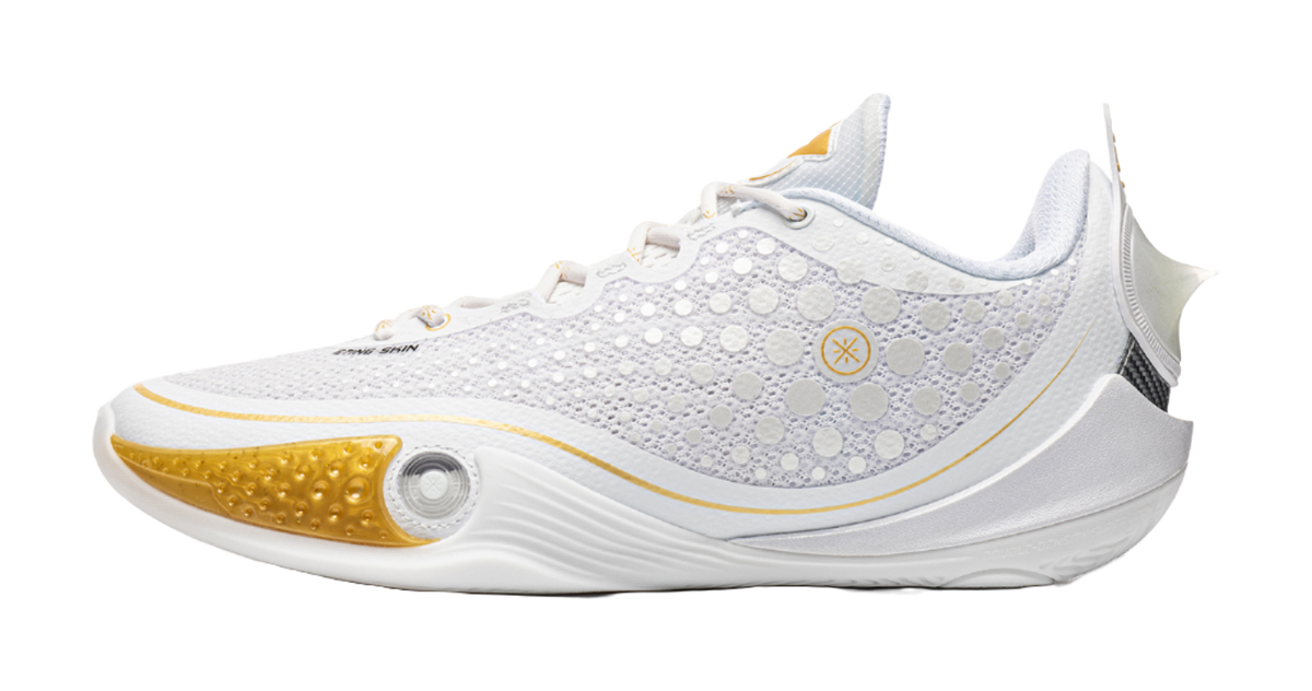 Low basketball shoe with white mesh upper and gold heel accent, lace-up front