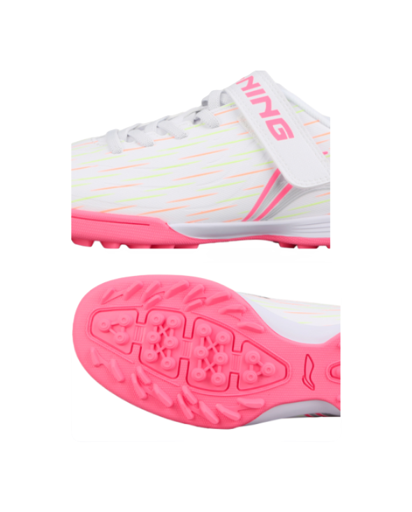 White youth turf shoe with pink sole, side profile and studded outsole close-up