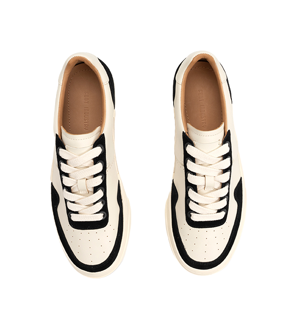 Low-top skate shoes, two front views, off-white uppers with black side panels, laces.