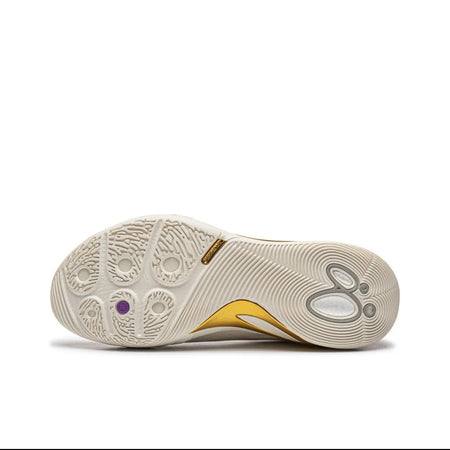 A close-up of a sneaker's outsole, showing a cream-colored rubber pattern with a small gold accent and a tiny purple detail, labeled as '白金' (which translates to platinum or white gold) on a white background.