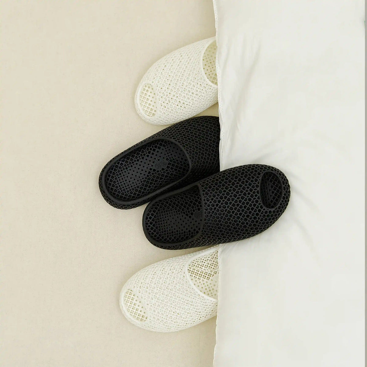 3D printed slippers, black and white open-toe slides with perforated knit uppers