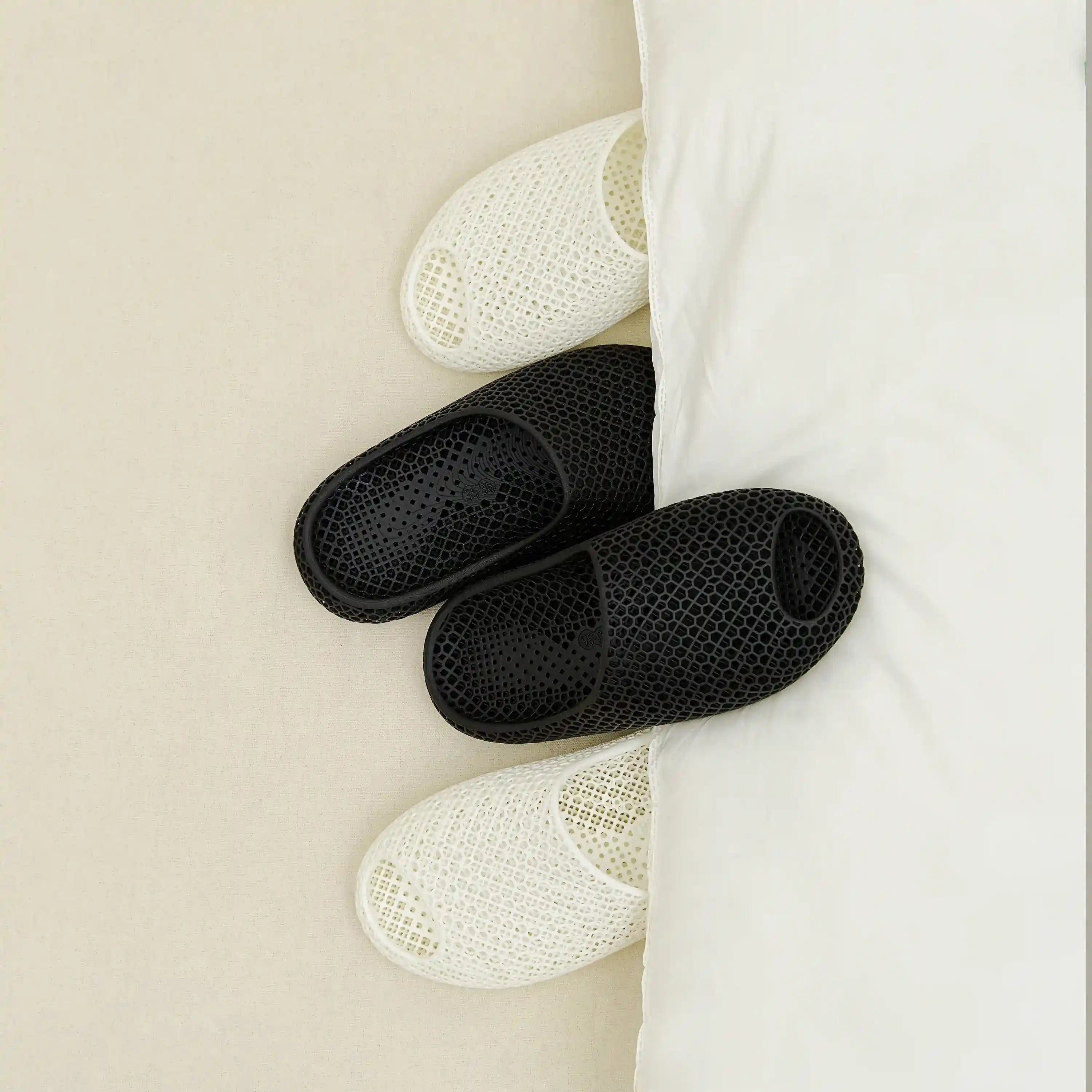 3D printed slippers, black and white open-toe slides with perforated knit uppers