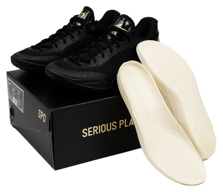 Black lace-up basketball shoes with beige insoles and box packaging shown