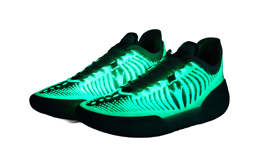 Dark basketball shoe with neon-green lighted knit upper and white laces