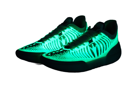 Dark basketball shoe with neon-green lighted knit upper and white laces