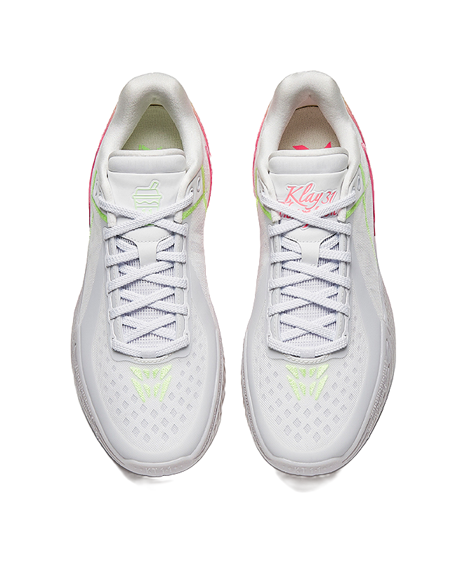 Pair of white basketball shoes with lace-up fronts and green logo accents