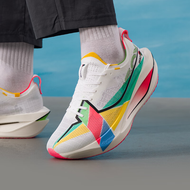 Xtep marathon racing shoe on foot with white upper and multicolor panels, green stripe.