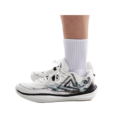 Lightweight basketball shoe on ankle, cream upper with black trim and blue-gray graphic