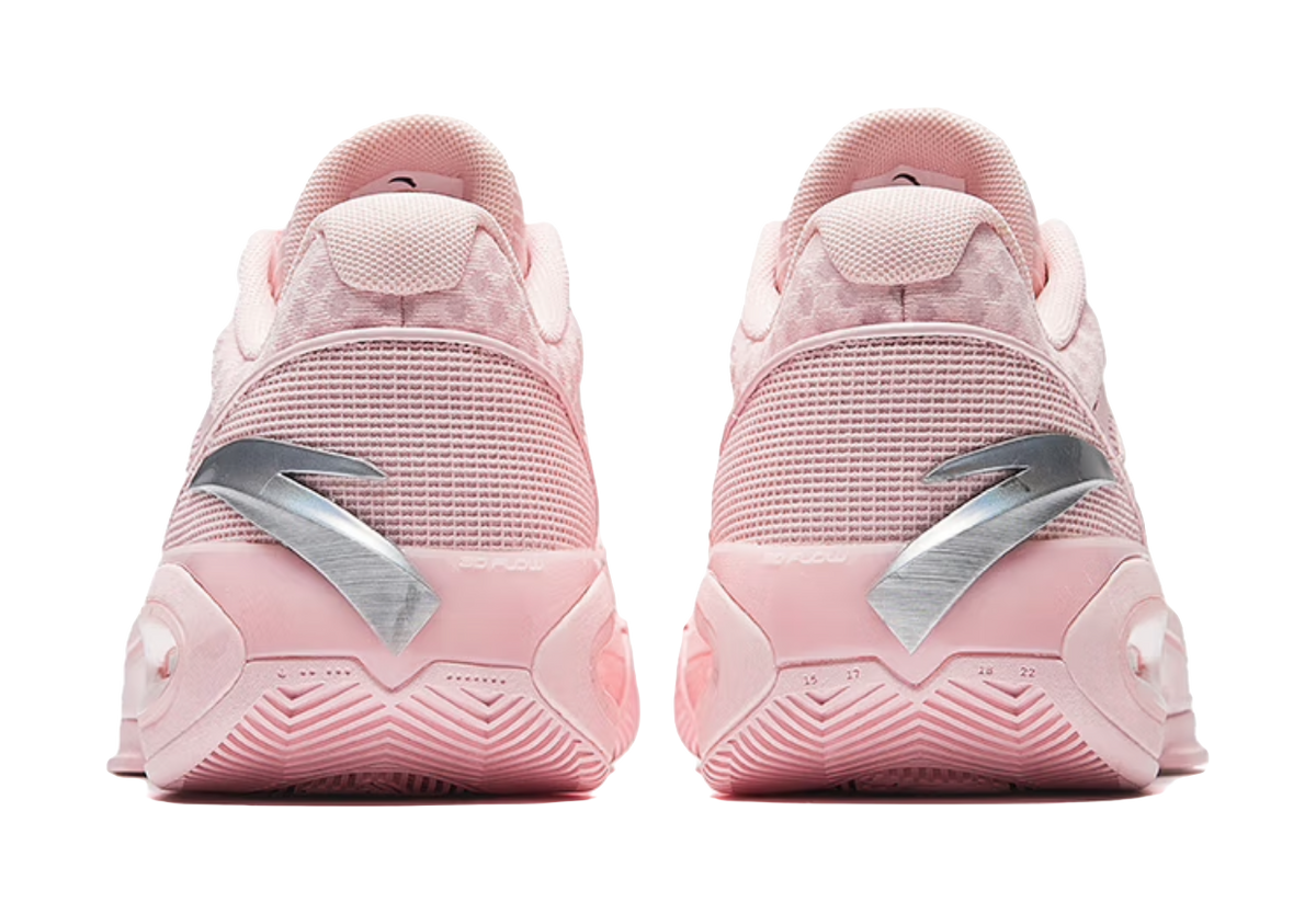 Back view of light pink low-top basketball shoes with heel tabs and panel details