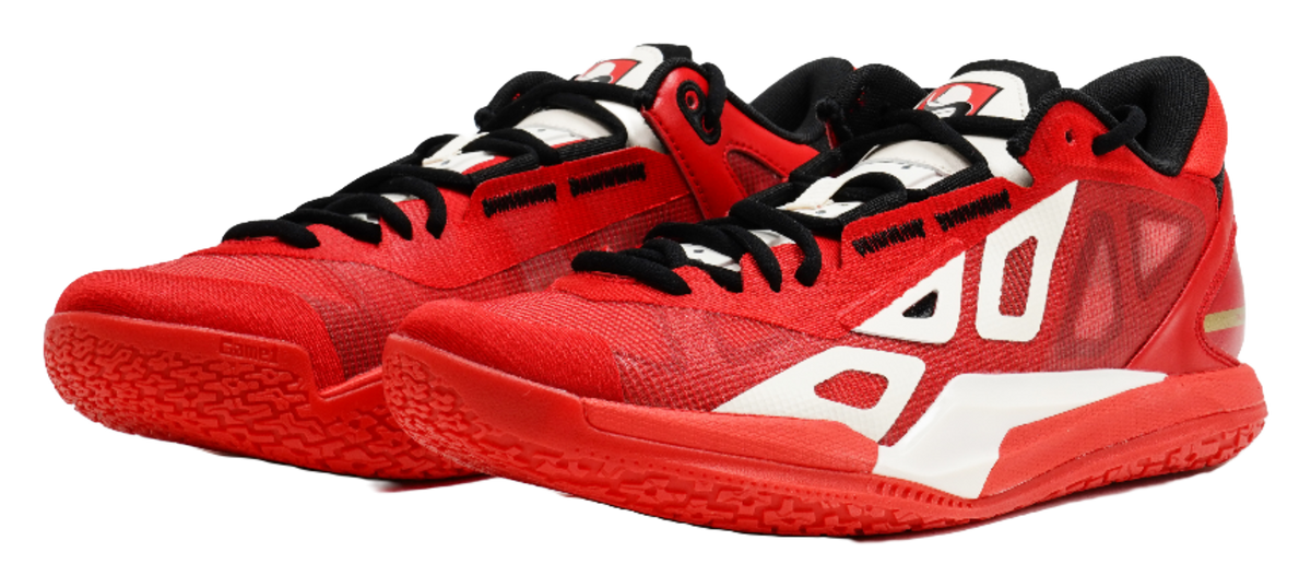 Red low-top basketball shoe with white stripes, black collar, and thick red sole