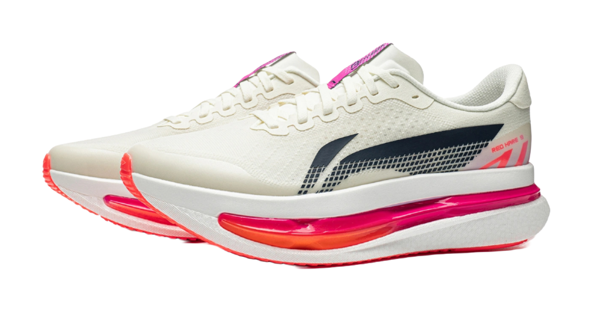 Men's running shoes with white upper, navy accent panel, and pink-and-red midsole