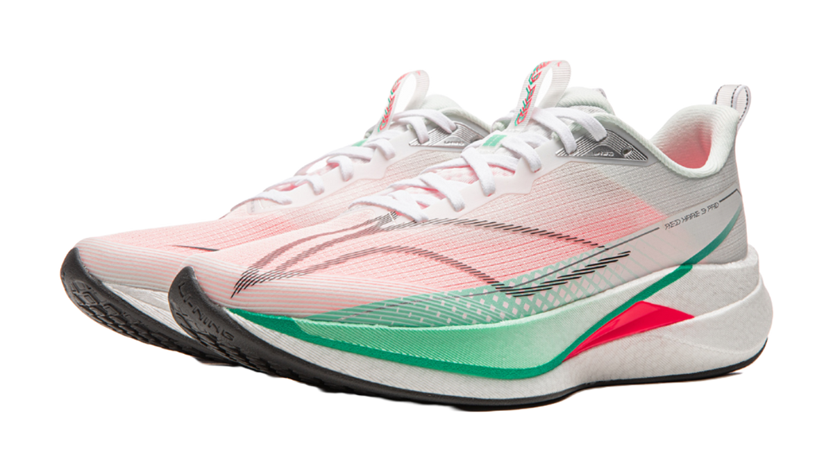 Running shoe three-quarter view in white and pink with laces, gray heel panel, green edge trim