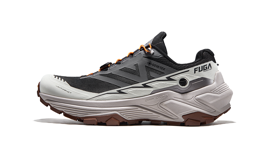 Gray and black trail running shoe with orange lace accents and thick tread sole, side view.